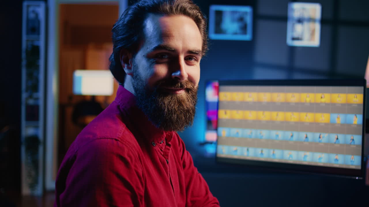 retrato de un fotógrafo sonriente utilizando un software de edición de fotos en una pantalla de pc en un estudio multimedia