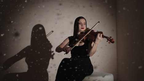 woman playing violin in a studio setting with snow