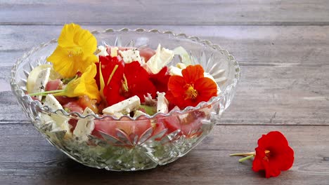 dejar caer coloridas flores comestibles en una ensalada fresca