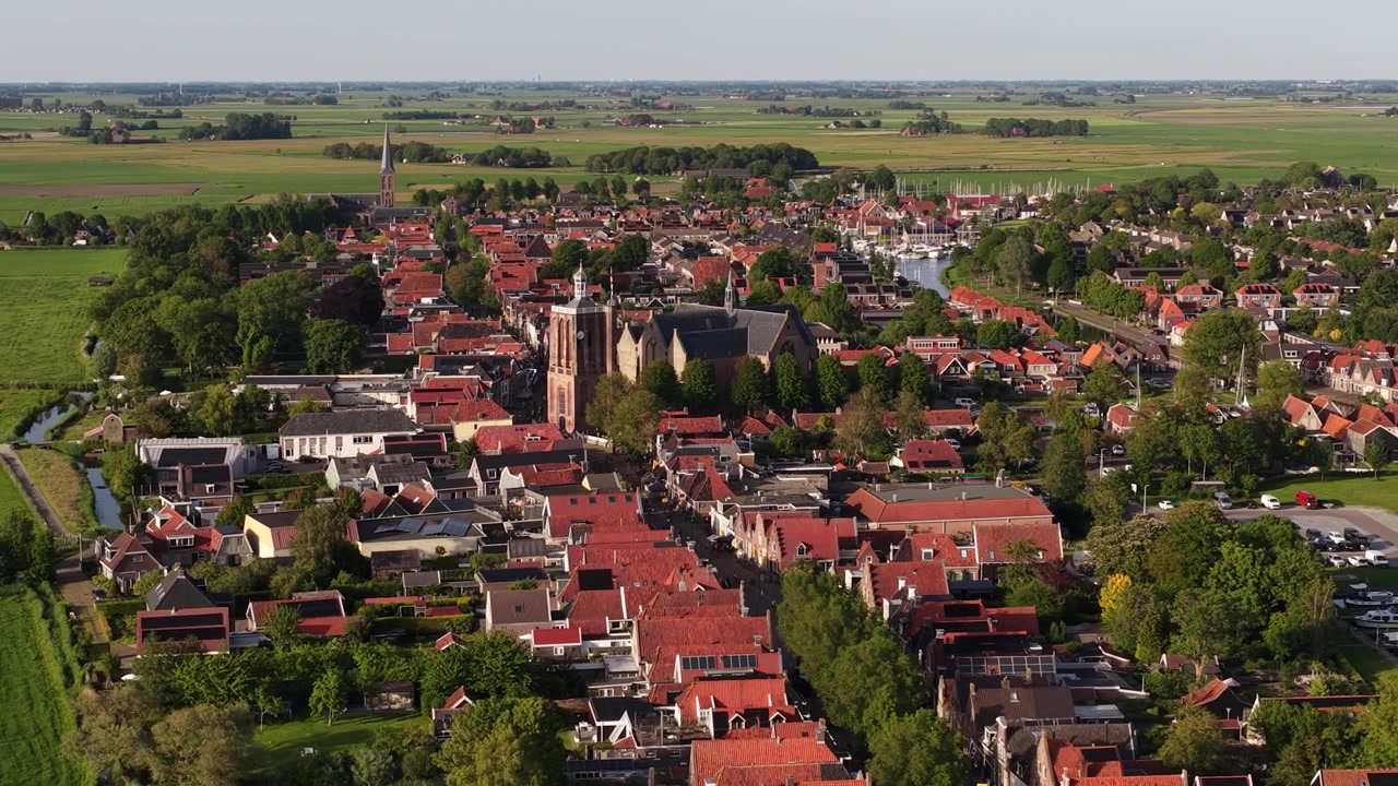Luftfoto af Workum i Friesland, der viser en historisk hollandsk by med kanaler, traditionelle huse, vindmøller og kulturarv i Súdwest-Fryslân.