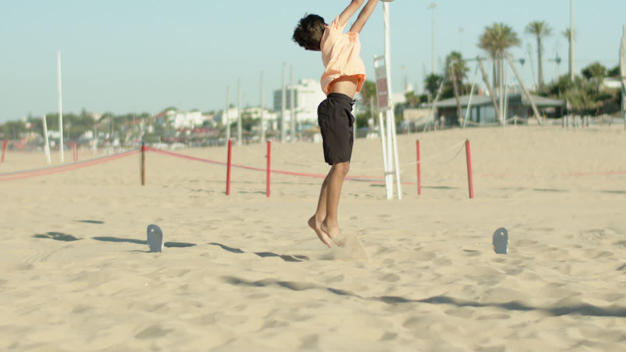 movimiento vertical del niño manteniendo la meta y limpiando la pelota en la playa