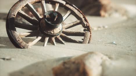 large wooden wheel in the sand