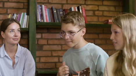 Joven-Rubio-Con-Gafas-Tocando-El-Ukelele-Para-Su-Profesor-Y-Compañeros-De-Clase