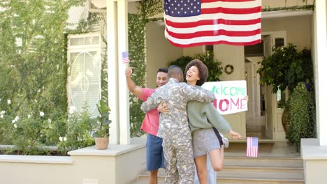 Feliz-Y-Diverso-Soldado-Abrazando-A-Sus-Amigos-Con-La-Bandera-Americana