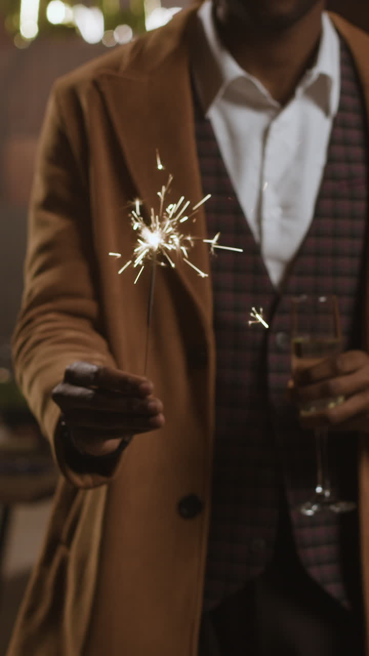 Man celebrating with sparkler and drink
