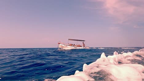 Punto-De-Vista-De-La-Superficie-Del-Agua-De-ángulo-Bajo-Del-Sendero-De-La-Estela-Del-Barco-Con-La-Reserva-Natural-Riserva-Dello-Zingaro-De-Sicilia-En-El-Fondo