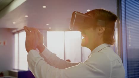 vista lateral de un joven ejecutivo caucásico usando auriculares de realidad virtual en una oficina moderna 4k
