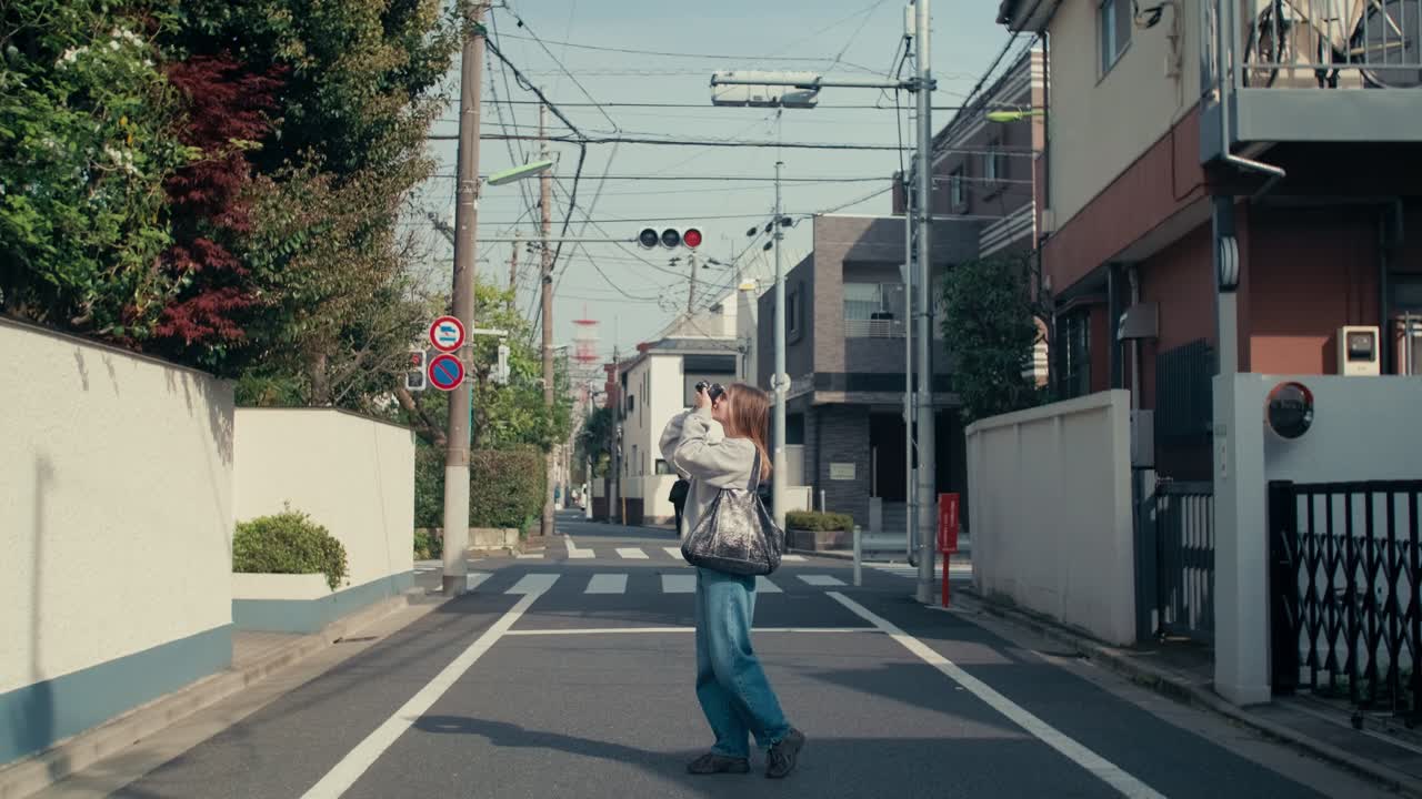 Girl capturing moments in Japan with vintage camera.