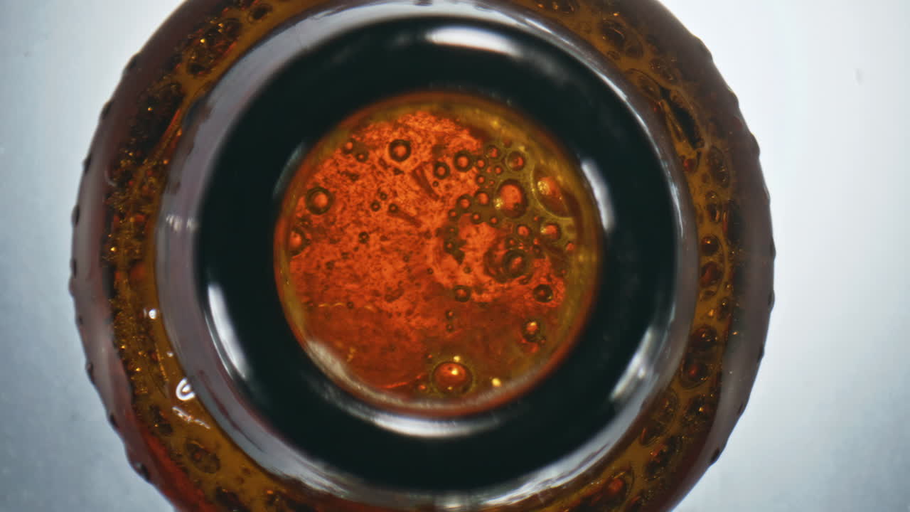 vaso de cerveza espumosa de primer plano. licor gaseoso alcohólico burbujeando dentro de la botella