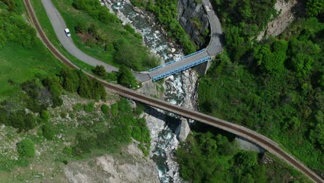 bird's eye view over railroad and bridge in the alps, furkapass of switzerland - drone shot