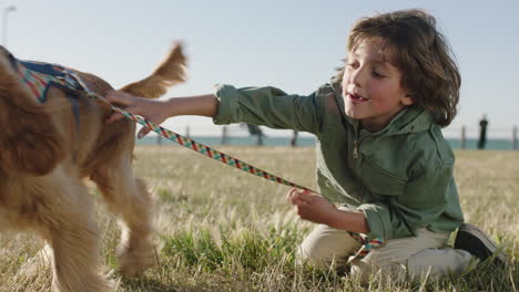 portrait of happy little boy embracing hugging pet dog running away cheerful sunny day at seaside park