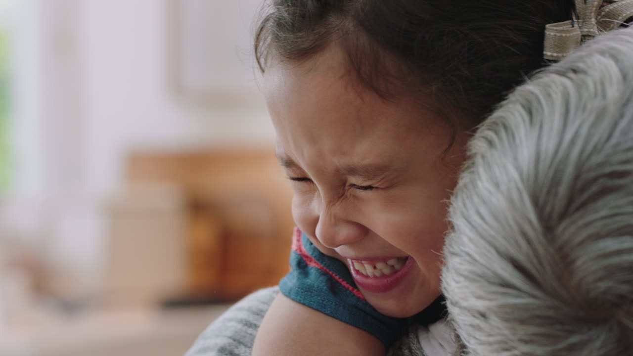happy little girl hugging grandmother smiling embracing granddaughter loving granny enjoying affection at home family concept 4k footage