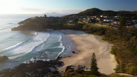 cinematic drone shot of scotts head beach and town in australia, into the sun