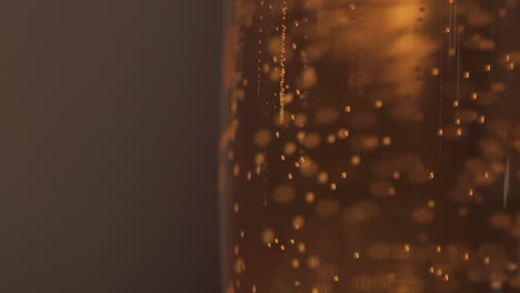 close up edge of beer glass slow motion bubbles rising