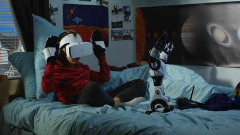 boy playing vr game with robotic arm in his bedroom