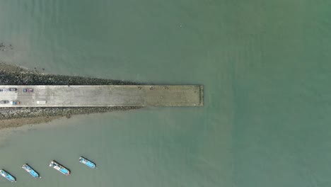 pescadores esperando barcos en el muelle