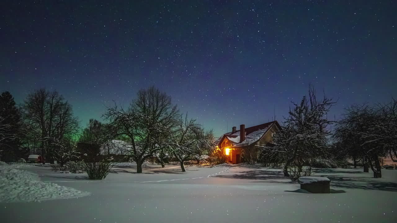 노르웨이 농가에서 눈 덮인 겨울날 지평선에 별과 북극광이 있는 밤하늘의 저속 촬영