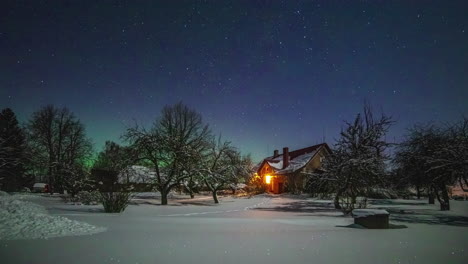 time lapse shot of night sky with stars and northern lights at horizon during snowy winter day in farm house,norway