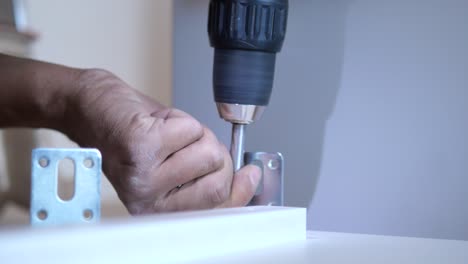 person assembling furniture with screwdriver