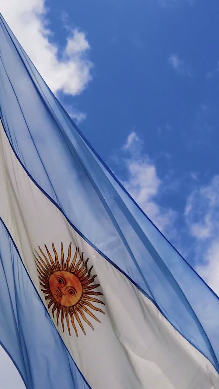 Drapeau argentin en gros plan flottant sur fond de ciel bleu, format vertical, Buenos Aires