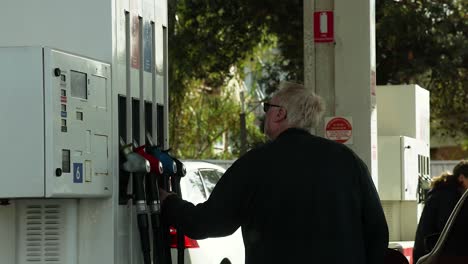 man refueling car at a gas station