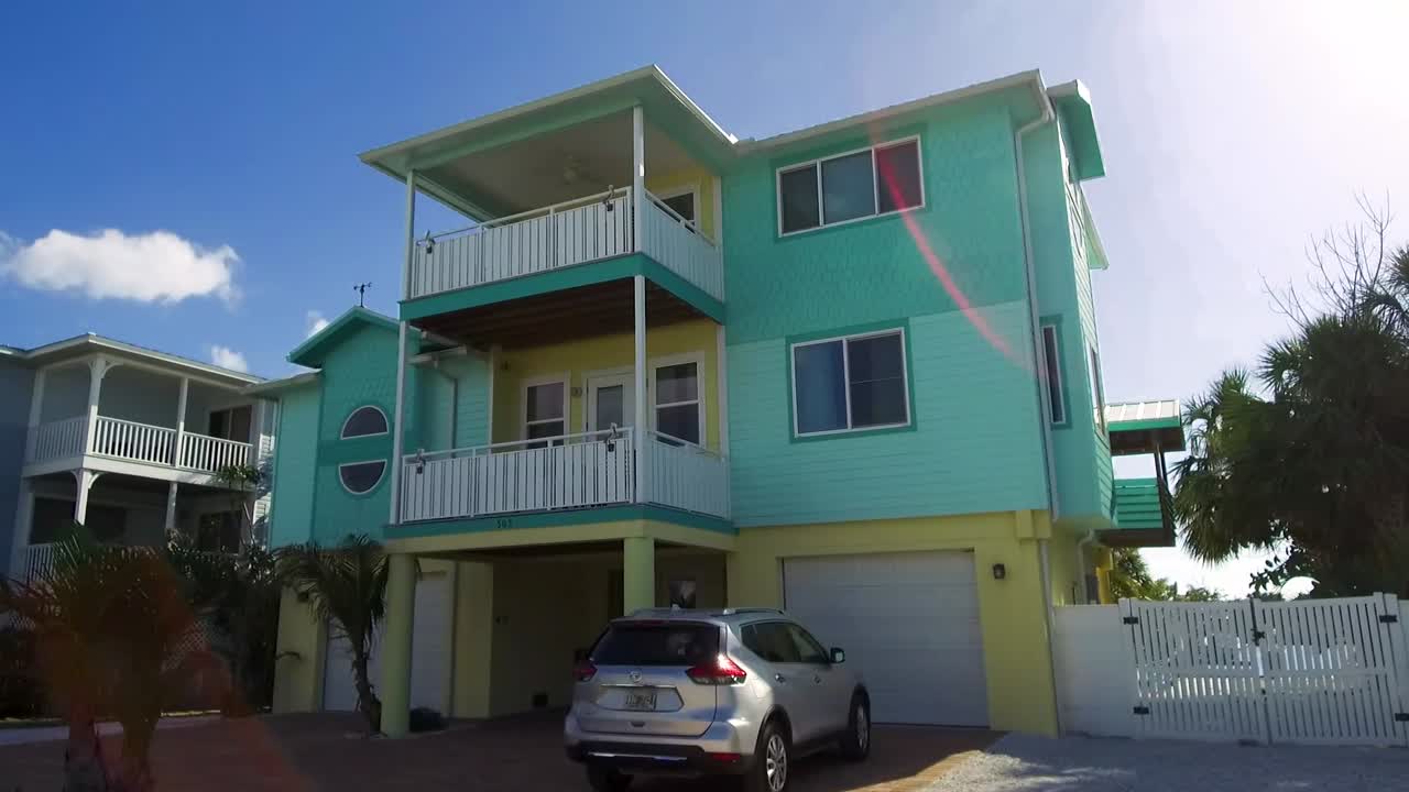 una toma en movimiento lento que pasa por varias casas de vacaciones coloridas en la isla anna maria, florida