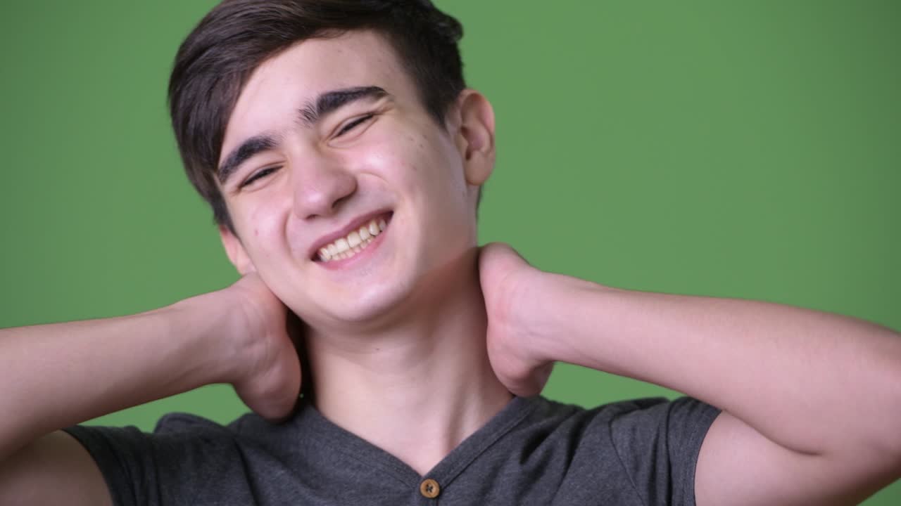 초록색 배경에 젊은 잘생긴 이란 십대 소년