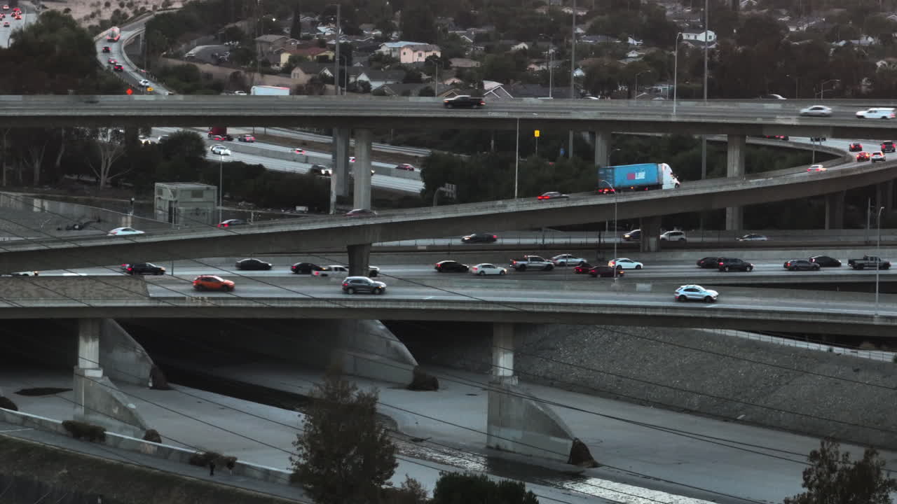 Telephoto drone shot of traffic on elevated freeway roads in Los Angeles, sunset