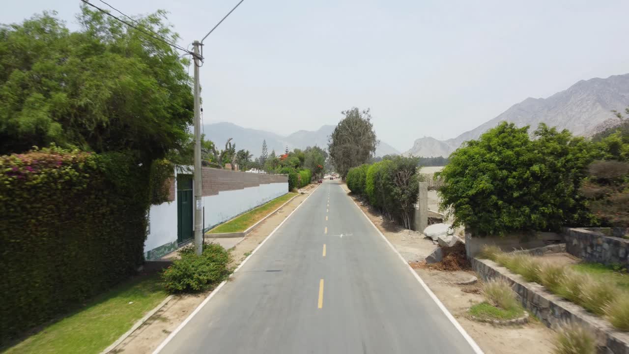 뒤로 날아가는 드론을 따라 거리를 달리는 오토바이 운전자