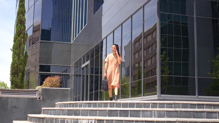 Mujer de negocios bajando las escaleras mientras habla por el móvil