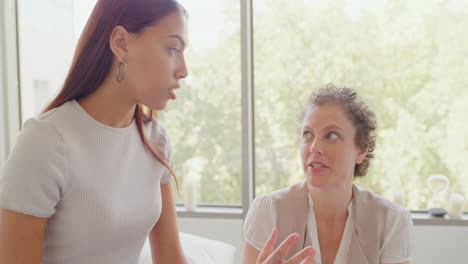 a chiropractor talking to young patient