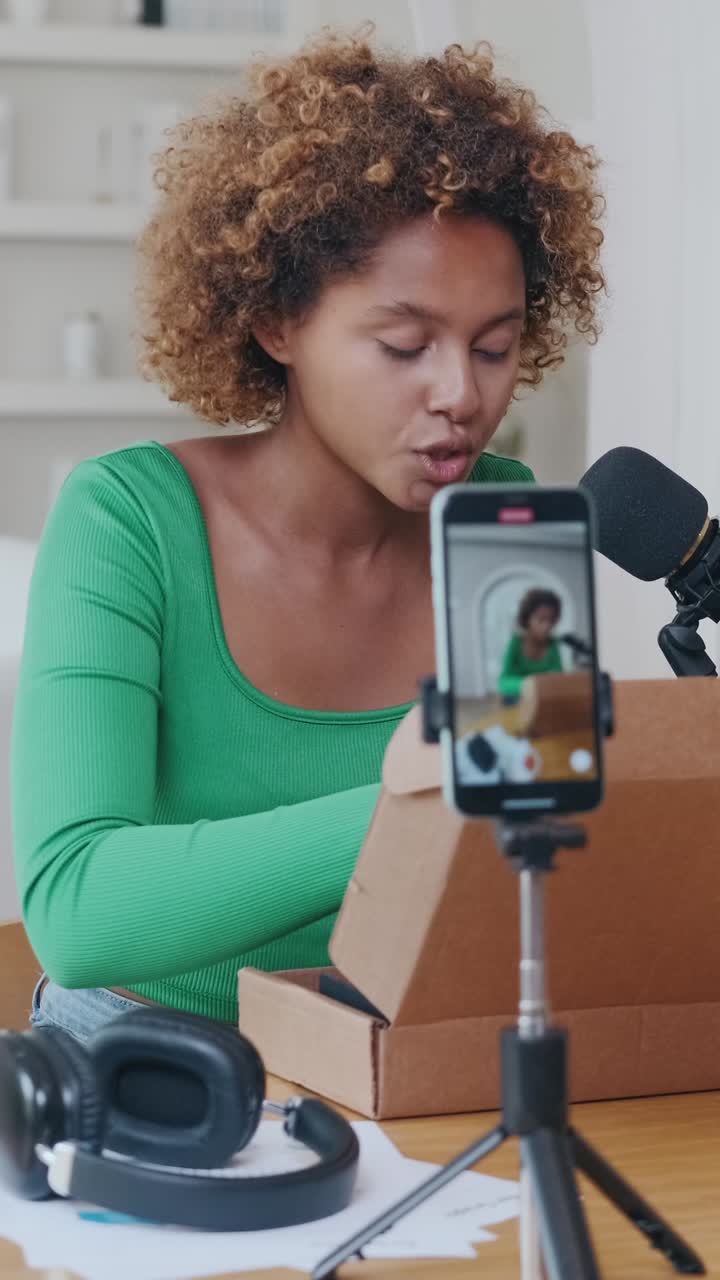Donna che fa un vlog di unboxing con smartphone e microfono