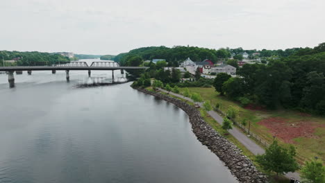 Drone-Orbit-of-Riverbank-and-Bridge-in-Bangor,-Maine