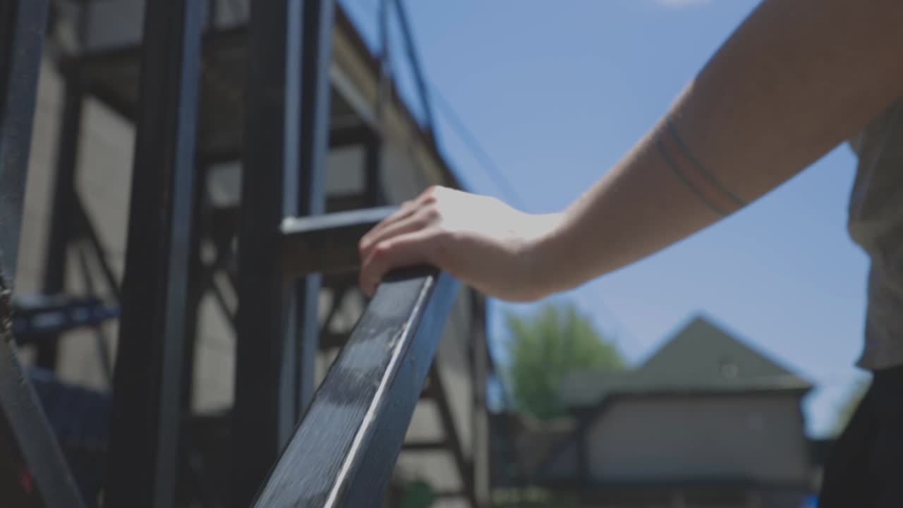 Man's Hand Holding On The Metal Railings While Climbing Up On The Stairs Outdoor.- close up