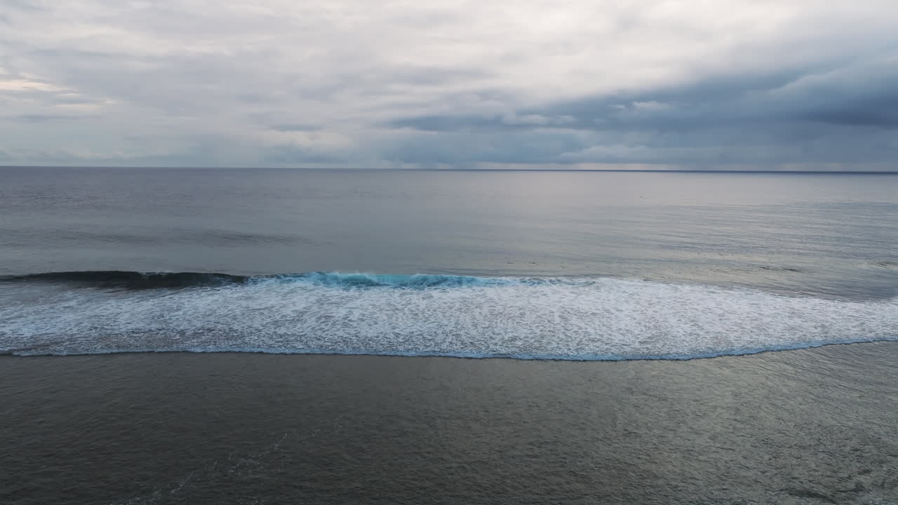 Slow motion footage of foamy tides from Suth Pacific Ocean approaching shore of beach in Cook Islands.