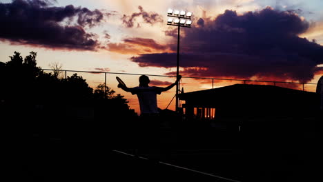 silhouette of a tennis player at sunset playing for title