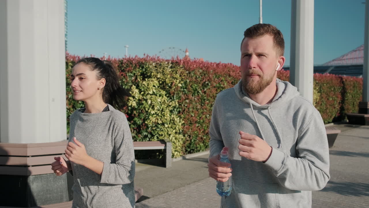 한 커플 이 도시 공원 에서 달리고 있다