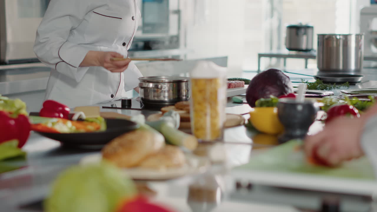 Female chef cooking gourmet soup recipe and doing taste test