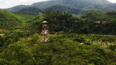 Zoom-Aéreo,-Torre-De-Vigilancia-Contra-Incendios-En-Medio-De-Un-Exuberante-Bosque-Tropical-Verde