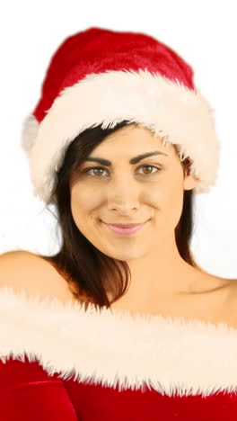 una mujer bonita sonriente posando en un traje sexy de papá noel.