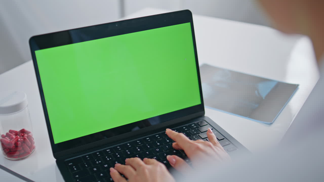 Woman therapist typing mockup laptop at healthcare clinic closeup. Doctor hands