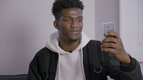 Portrait-of-happy-young-man-recording-video-message