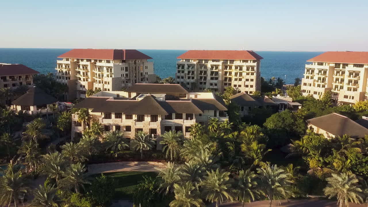 Drone che si allontana rivelando ville, palme e il mare sulla costa di Dubai