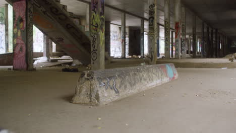 caucasian boy skateboarding in a ruined building.