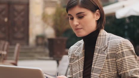 businesswoman working on laptop in cafe outdoor.