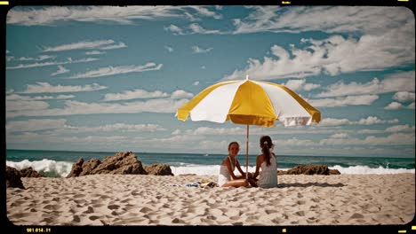 two girls on a beach under a parasol