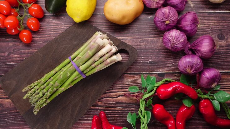 Fresh Asparagus and Various Vegetables on a Wooden Table