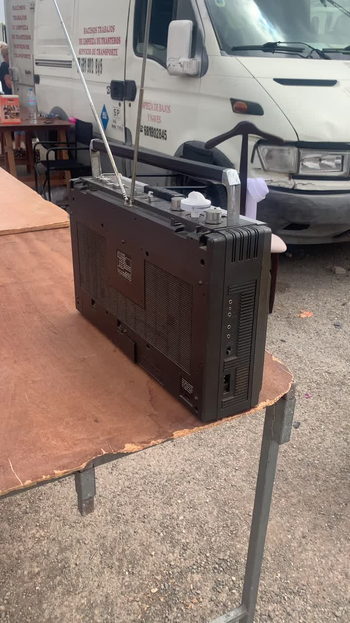 An old transistor radio is prominently displayed at the open-space flea market, drawing attention with its vintage charm, showcased in a captivating vertical video format.