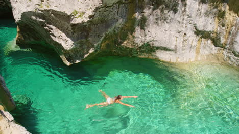 woman swimming in a beautiful green river canyon