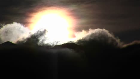 nubes moviéndose sobre montañas y sol